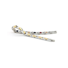 Alchemist stainless steel bracelet unclasped and folded to display alternating polished steel and gold links with embedded elements.