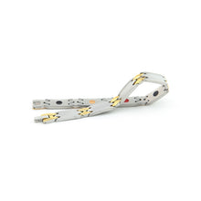 Alluring gold and stainless steel bracelet unclasped and folded to display interlocking matte and polished gold links with embedded elements.