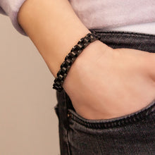 Female model wearing the Black Knight bracelet, featuring matte black segments bordered by polished black stainless steel rows.