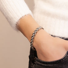 Female model wearing the Elegant Flower bracelet, crafted from polished stainless steel links.