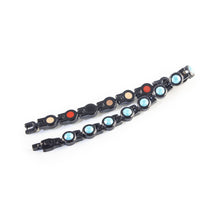 Obsidian Tide bracelet unclasped and folded to display black steel links with turquoise crystals.