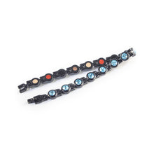 Polaris bracelet unclasped and folded to display black steel links with aqua crystals.