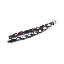 Bracelet folded and unclasped to display pink crystal accents and link design.