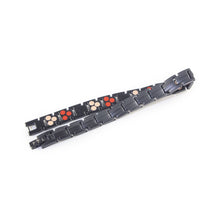 Shadow bracelet unclasped and folded to display link design and embedded elements.