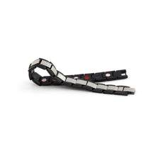 Swell stainless steel bracelet unclasped and folded to display angular link design and single row of embedded negative ion elements.