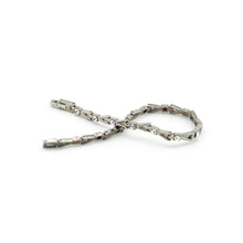 Vibrant Spark titanium bracelet unclasped and folded to display refined link pattern and crystal details.