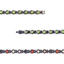 Close-up view showing green crystals and polished black interlocking links.